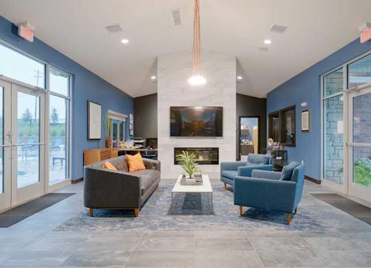 Resident clubhouse with fireplace, lounge seating, and modern finishes in an open-concept community gathering space.