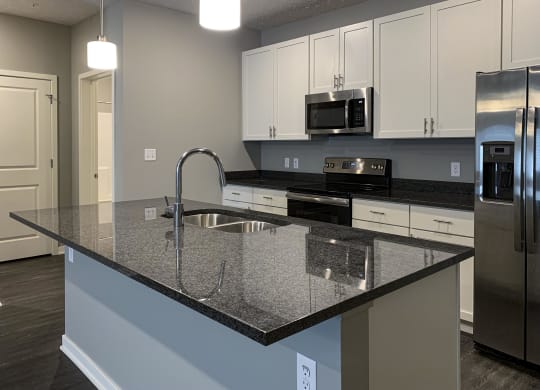 Large kitchen island with granite countertops and sink