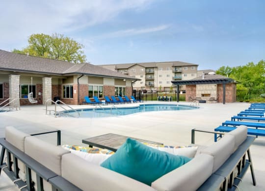 Resort style pool with lounge chairs and couches outside the clubhouse at The Flats at Shadow Creek