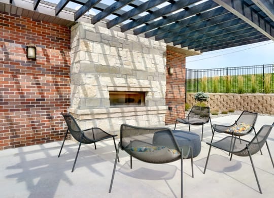 Outdoor brick fireplace with chairs positioned around it