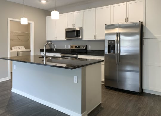 Kitchen with white cabinets and dark granite counters The Flats at Shadow Creek in Lincoln Nebraska