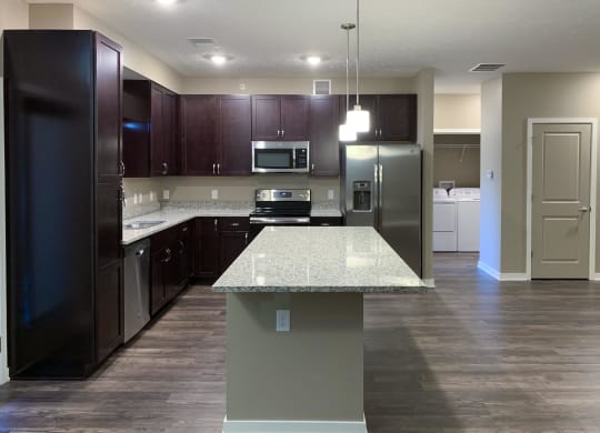 Kitchen with dark brown cabinets and large kitchen island and matching stainless steel  appliances