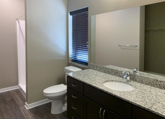 Bathroom with dark brown vanity and large mirror