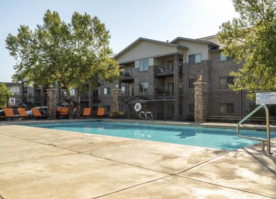 a swimming pool with lounge seating  at Grand Legacy apartments and townhomes in west Omaha NE 68130