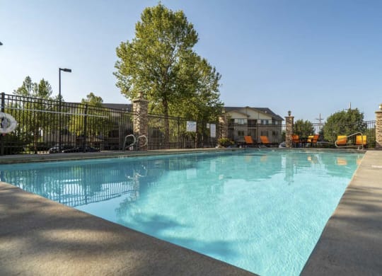 a pool with orange lounge chairs