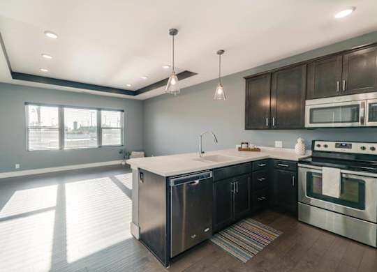 A modern kitchen with stainless steel appliances and wooden cabinets.