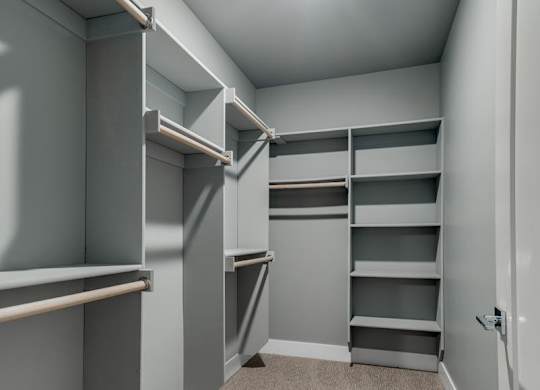 A room with grey walls and a carpeted floor with a white door on the right.