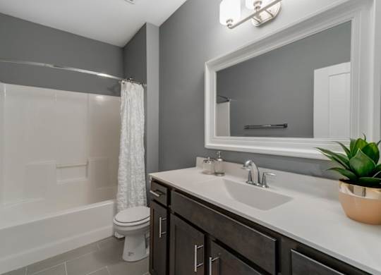 A bathroom with a white tub, sink, and toilet.