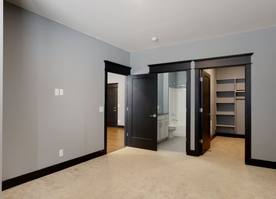 master bedroom with a walk in closet and a bathroom