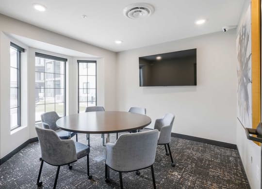 The business conference room featuring a table with chairs and a tv