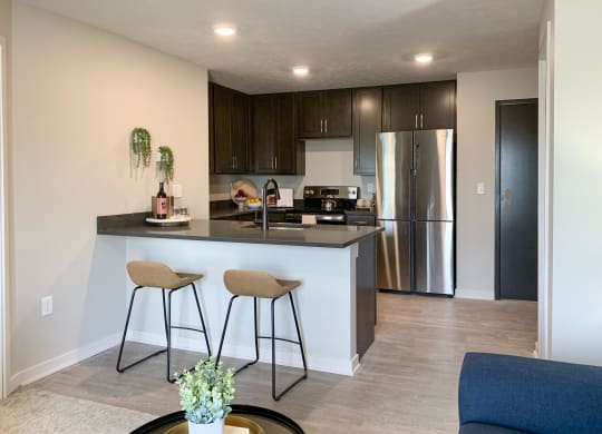 a kitchen with a large island with two stools in front of it
