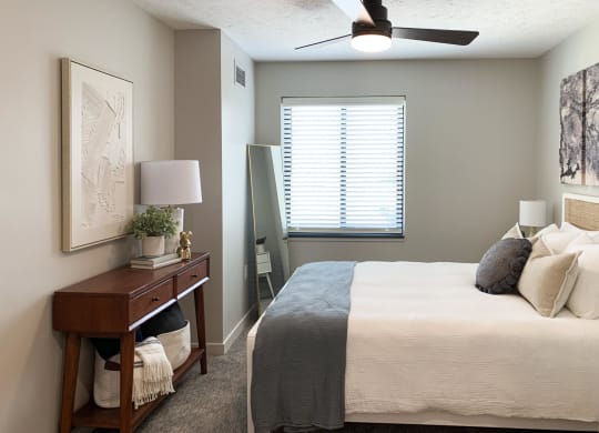 a bedroom with a ceiling fan and a window