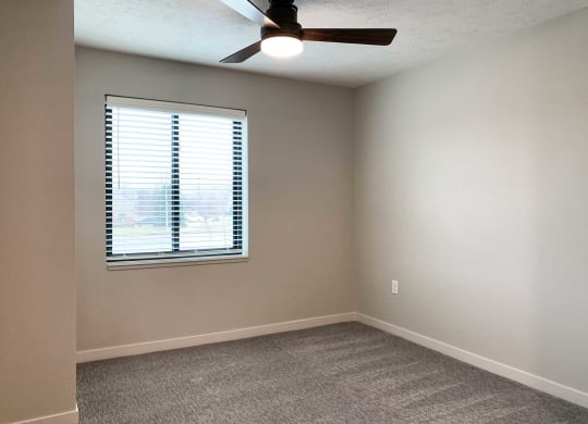 a bedroom with a ceiling fan and window