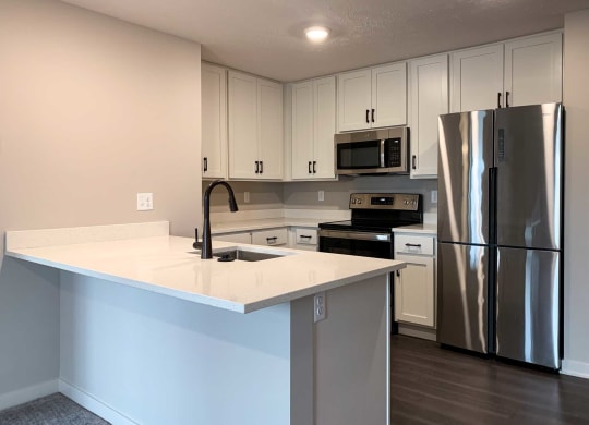 a kitchen with white finishes and stainless steel appliances