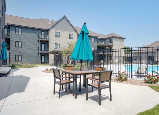 a courtyard space with a table and chairs and umbrella