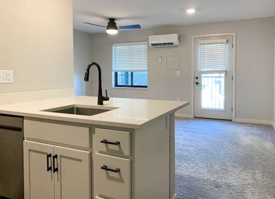 a kitchen peninsula with white quartz countertops and white cabinets