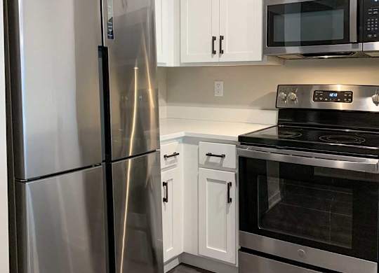 a modern kitchen with a stainless steel refrigerator and oven