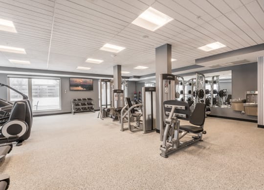 View of expansive gym with weightlifting machines at The Preserve apartments in Bloomington