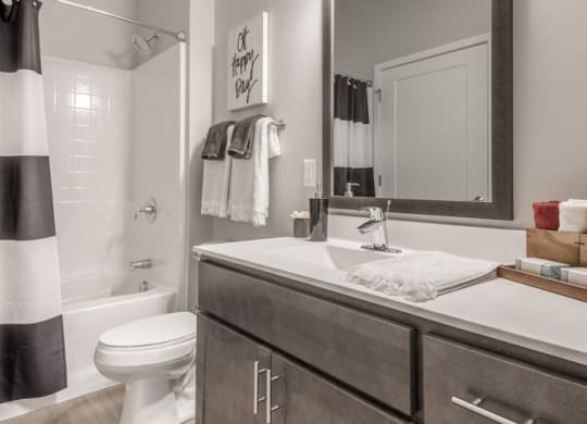 Interiors- Bathroom with dark cabinets and white, cultured-marble countertops at The Preserve at Normandale Lake