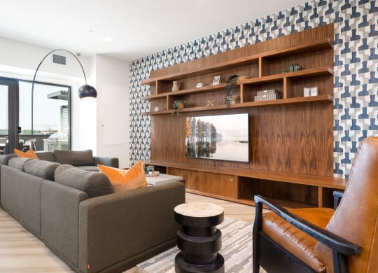 Community space television lounge with grey couch and yellow accent pillows