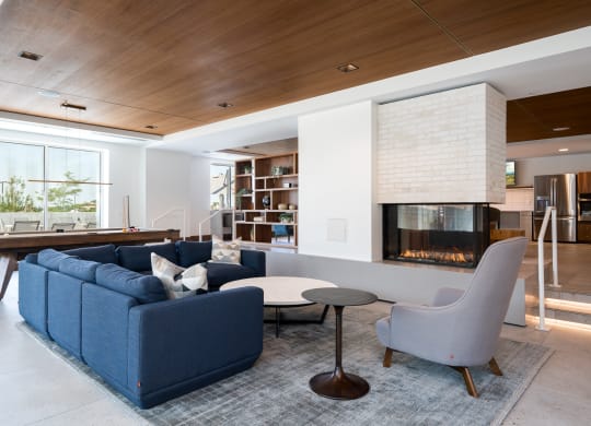 entertainment suite with couch seating and a cozy fireplace. Pool table behind the couch.