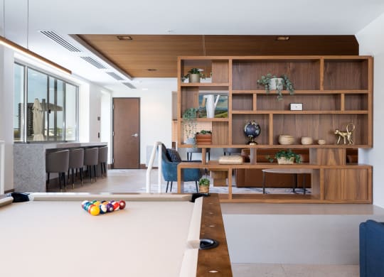Pool table in the entertainment suite with aesthetic wooden shelf in the back