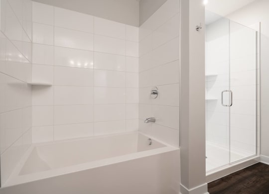 Bathroom with bath tub and walk in glass shower to the right