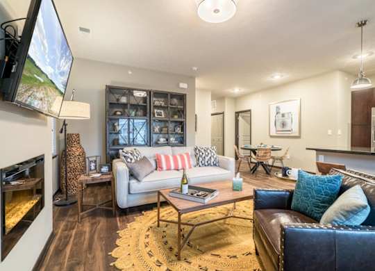A modern living room with a fireplace and a large TV mounted on the wall.