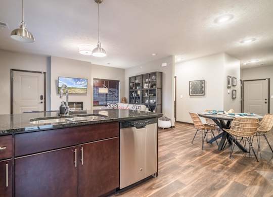 A kitchen with dark wood cabinets and a black countertop.