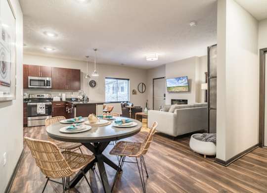 A modern kitchen with a dining table set for two.