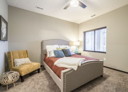 Interiors-1 bedroom apartment bedroom with ceiling fan, queen bed and chair