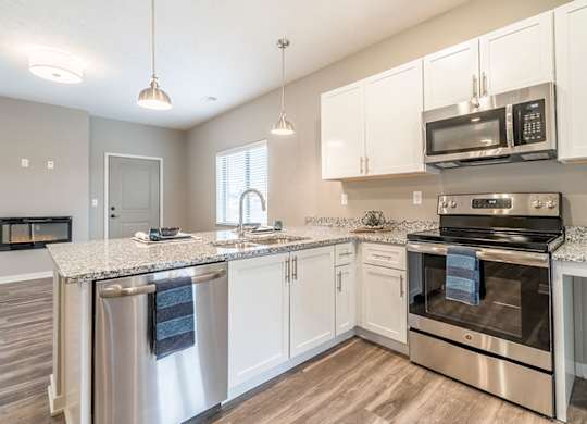 Apartment kitchen with white cabinets and stainless steel appliances