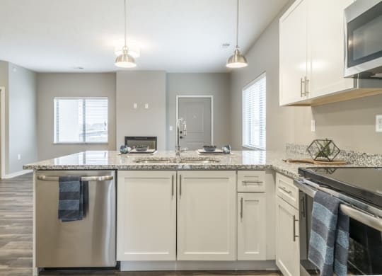 Interiors-Contemporary kitchen with white cabinetry, light granite countertops and stainless steel appliances at The Villas at Falling Waters