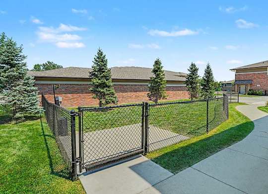 A black metal fence surrounds a green lawn.