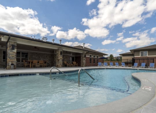 Resort-style pool with lounge seating at The Villas at Falling Waters townhomes for rent in West Omaha NE