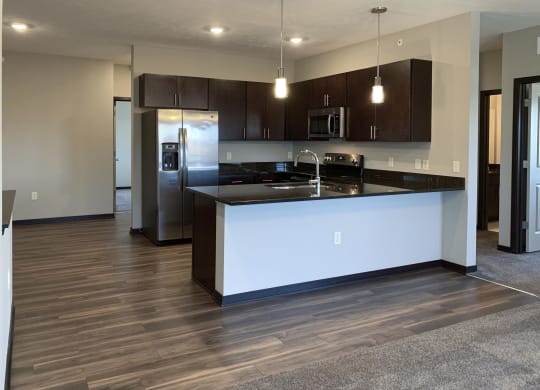 Kitchen with dark brown cabinets and matching stainless steel appliances at the villas at mahoney park