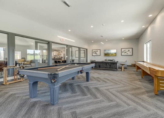 Large game room including TVs, pool tables, and shuffle board at The Villas at Mahoney Park
