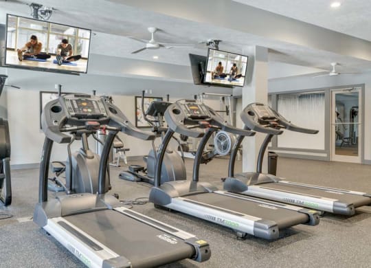 Fitness center including TVs at The Villas at Mahoney Park
