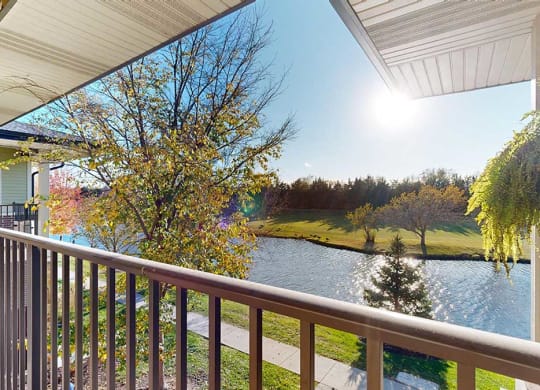 a balcony with a view of a pond at the neighboring golf course