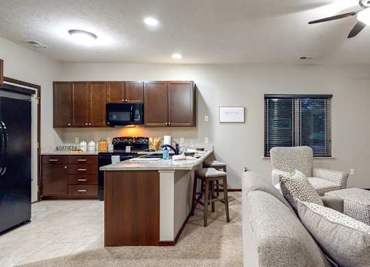 A kitchen with a refrigerator, microwave, and cabinets.