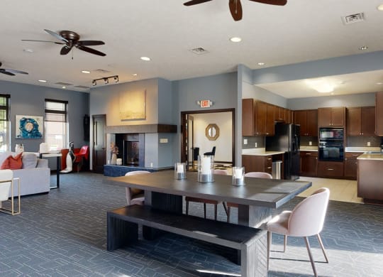 the clubhouse with a table and chairs and a kitchen in the background