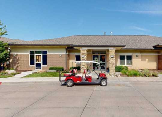 a golf cart parked in front of the clubhouse building at the villas at wilderness ridge