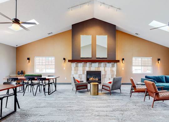 A clubhouse main room with a fireplace and multiple seating areas