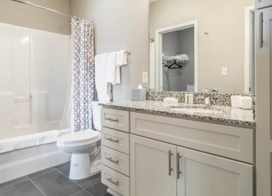 Bathroom with granite counter tops and gray slate flooring at The Villas at Mahoney Park