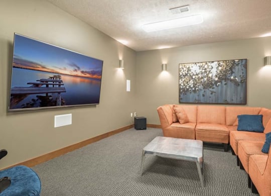 Theater room with large TV and couches at Villas of Omaha townhome apartments in northwest Omaha NE 68116