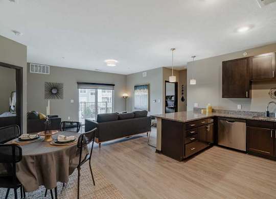 A modern kitchen with dark wood cabinets and a dining table set for two