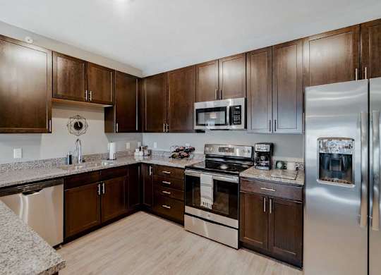 A modern kitchen with brown cabinets and stainless steel appliances