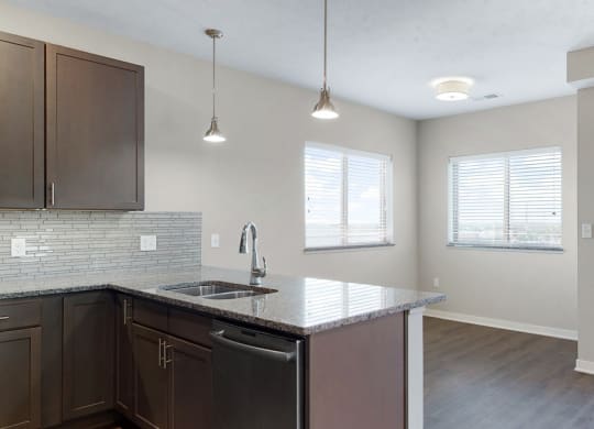 The 2 bedroom Marigold with den floor plan at WH Flats features an open eat-in kitchen area with granite countertops and large peninsula.