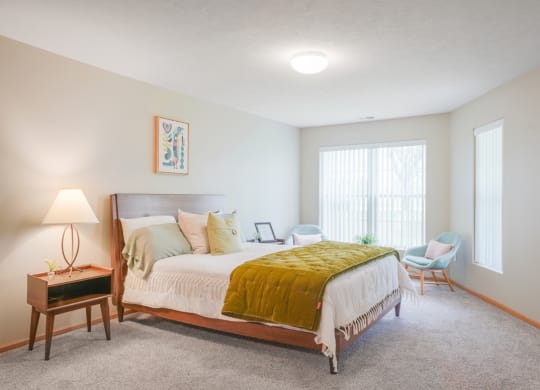 Furnished bedroom with a bed and chairs and a window
