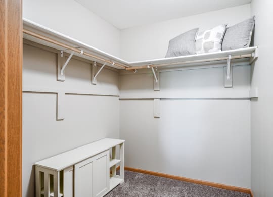 a walk in closet with shelves